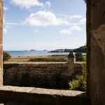 Blick durch ein offenes Ruinenfenster aufs Meer mit Inseln