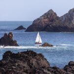einsames Segelboot in felsiger Mehresbucht